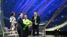 Bộ trưởng Bộ GD-ĐT Phùng Xuân Nhạ tặng hoa cho thầy Lưu Văn Hóa