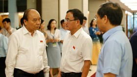 Thủ tướng Nguyễn Xuân Phúc trao đổi với các ĐBQH ngày 13-6. Ảnh: QUANG PHÚC