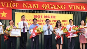 Chủ tịch UBND TPHCM Nguyễn Thành Phong và Phó Chủ tịch UBND Trần Vĩnh Tuyến tặng bằng khen cho các doanh nghiệp. Ảnh: VIỆT DŨNG