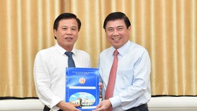 Chủ tịch UBND TPHCM Nguyễn Thành Phong trao quyết định bổ nhiệm cho đồng chí Nguyễn Hữu Tín. Ảnh: VIỆT DŨNG