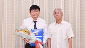 Phó Chủ tịch UBND TPHCM Võ Văn Hoan trao quyết định cho ông Trần Quang Minh. Ảnh: VIỆT DŨNG
