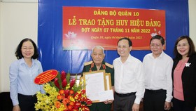 Phó Bí thư Thành ủy Nguyễn Văn Hiếu trao tặng Huy hiệu 75 năm tuổi Đảng cho Thiếu tướng Đoàn Văn Khoan. Ảnh: TRẦN YÊN