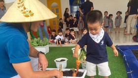 Helping children to get familiar with the nature in the Kindy City International Kindergarten. Photo by Hoang Hung