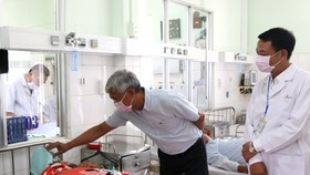 Deputy chairman of HCMC People’s Committee Vo Van Hoan (L) visits patients at a hospital in Binh Phuoc Province (Photo: SGGP)