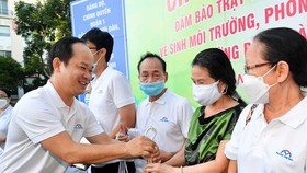 Chủ tịch UBND quận 1 Lê Đức Thanh tặng chậu cây xanh cảm ơn các hộ dân. Ảnh: VIỆT DŨNG 