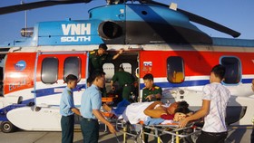 Các chiến sĩ, bác sĩ vận chuyển bệnh nhân từ trực thăng về bệnh viện Ảnh: TRẦN CHÍNH