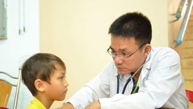 PGS-TS-BS Lê Minh Khôi đang thăm khám cho bệnh nhi
