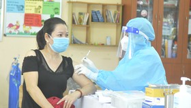 Nhân viên y tế tiêm vaccine cho người dân tại Trường Tiểu học Bình Hưng, huyện Bình Chánh. Ảnh: CAO THĂNG