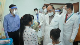 Chủ tịch nước Nguyễn Xuân Phúc thăm hỏi, tặng quà bệnh nhi tại Bệnh viện Nhi đồng Thành phố. Ảnh: CAO THĂNG