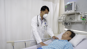Bác sĩ Phạm Phước Mẫn đang thăm khám người bệnh sau thực hiện can thiệp mạch vành