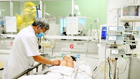 Bác sĩ chăm sóc bệnh nhân đang điều trị sốc sốt xuất huyết tại Bệnh viện Bệnh Nhiệt đới TPHCM