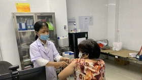 Nhân viên Trung tâm y tế quận 11 tiêm vaccine cho người dân trên địa bàn quận