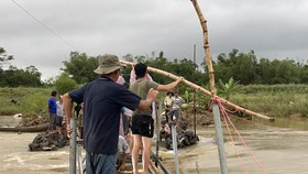 Người dân Quảng Ngãi làm cầu tạm cheo leo để vượt sông Trà Khúc sau ngập