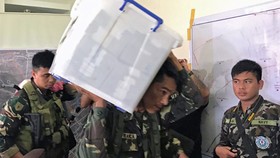 Binh sĩ mang thùng chứa 52,2 triệu peso (1,06 triệu USD) phát hiện trong tầng hầm một ngôi nhà phiến quân Maute chiếm ở TP Marawi, Philippines, ngày 6-6-2017. Ảnh: REUTERS