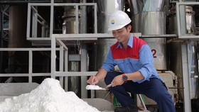Anh Hà Trầm Huy kiểm tra độ khô của muối  được sấy từ nguồn năng lượng thu hồi trong sản xuất