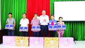  Ông Lưu Hoàng Tân - Chủ tịch, Giám đốc Công ty TNHH MTV Xổ số kiến thiết Đồng Tháp trao bảng tượng trưng  và quà cho 5 hộ nghèo