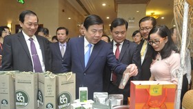 Chủ tịch UBND TPHCM Nguyễn Thành Phong và Chủ tịch UBND tỉnh Nghệ An Thái Thanh Quý, cùng các đại biểu tham quan khu trưng bày sản phẩm của doanh nghiệp Nghệ An, tại hội nghị. Ảnh: CAO THĂNG