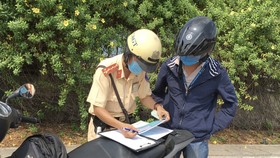 CSGT xử phạt người điều khiển phương tiện giao thông vi phạm khi qua hầm sông Sài Gòn. Ảnh: CAO THĂNG