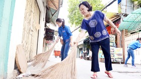 Người dân tham gia dọn dẹp vệ sinh ở một khu phố tại TPHCM. Ảnh: VIỆT DŨNG