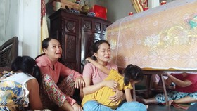 Chị Nguyễn Thị Ly và con gái ngồi thẩn thờ bên quan tài anh Khải