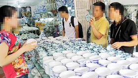Khách chọn mua chén đĩa tại Làng gốm Bát Tràng (Hà Nội)