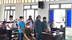 Luyện Xuân Tràng (người đeo kính) cùng 8 bị cáo khác tại phiên tòa. 