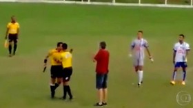 Trọng tài Murta cầm súng trong khi tranh luận với một thành viên đội Amantes da Bola.