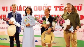 Phó Chủ tịch UBND TPHCM Nguyễn Thị Thu tặng hoa chúc mừng các du khách quốc tế tại lễ đón khách du lịch thứ 5 triệu đến TPHCM