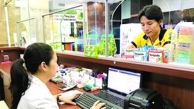 Nhân viên một nhà thuốc ở quận 7, TPHCM, truy cập dữ liệu thuốc qua mạng.  Ảnh: Hoàng Hùng