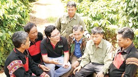 Anh Nguyễn Hữu Thông, chuyên gia nông nghiệp dự án Nescafé Plan cùng nông dân thảo luận cách chăm sóc cà phê trên vườn đạt hiệu quả tối ưu nhất