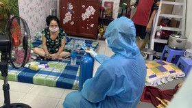 Một trường hợp F0 ở quận Bình Tân được hướng dẫn sử dụng bình oxy. Ảnh: MINH NGHĨA