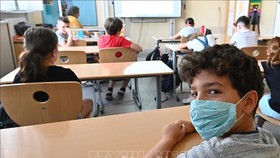 Học sinh đeo khẩu trang phòng lây nhiễm COVID-19 tại trường học ở châu Âu. Ảnh: AFP/TTXVN