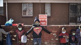 Trẻ em đeo khẩu trang phòng lây nhiễm COVID-19 tại Johannesburg, Nam Phi. Ảnh: AFP/TTXVN
