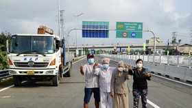 Người dân vui mừng khi chứng kiến đường cao tốc Trung Lương - Mỹ Thuận thông xe. Ảnh: HOÀNG HÙNG
