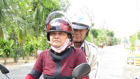 Chị Huỳnh Thị Thúy Linh chuẩn bị cho một cuốc xe ôm