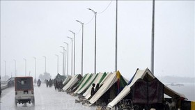 Người dân sơ tán tránh lũ ở trong các lều tạm tại Sukkur, tỉnh Sindh, Pakistan ngày 27-8-2022. Ảnh: AFP/TTXVN