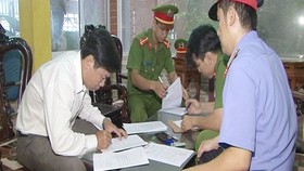 Lê Hữu Lam ký vào các giấy tờ liên quan trước khi bị bắt