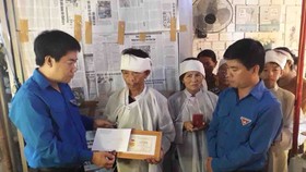 a mẹ đón nhận và nâng niu Huy hiệu “Tuổi trẻ dũng cảm" do Trung ương Đoàn TNCS Hồ Chí Minh truy tặng cho người con trai quên mình cứu người