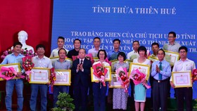 Phóng viên Báo SGGP (thứ 2 từ trái sang phải) nhận Bằng khen của Chủ tịch UBND tỉnh Thừa Thiên - Huế ​