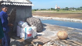 Muối làm ra khó tiêu thụ, ông Lê Doãn Sơn (62 tuổi, ở xã Hộ Độ) phải đóng muối vào các bao bì với hy vọng có thương lái đến mua