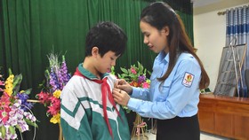 Phó Bí thư Tỉnh đoàn Hà Tĩnh Nguyễn Ny Hương trao huy hiệu “Tuổi trẻ dũng cảm” của Trung ương Đoàn TNCS Hồ Chí Minh cho em Phan Văn Quang