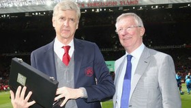 Sir Alex Ferguson (phải) trao quà lưu niệm cho HLV Arsene Wenger cuối tuần qua. Ảnh: Getty Images  