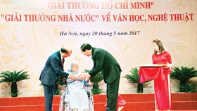 Chủ tịch nước Trần Đại Quang ân cần trao bà Nguyễn Thị San  giải thưởng Hồ Chí Minh cho nhà văn Xuân Thiều