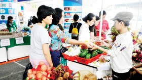 Người tiêu dùng mua rau củ quả tại gian hàng của tỉnh Lâm Đồng trong hội nghị Kết nối cung - cầu hàng hóa giữa TPHCM và các tỉnh, thành năm 2017                                                                                     Ảnh: THÀNH TRÍ