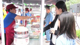 Người bán hàng rong được phép kinh doanh trên vỉa hè  đường Nguyễn Văn Chiêm (quận 1) theo giờ       Ảnh: KIỀU PHONG