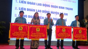 Chủ tịch Tổng LĐLĐ Việt Nam Bùi Văn Cường trao cờ xuất sắc  chúc mừng các tập thể