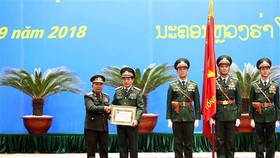 Thượng tướng Chansamone Chanyalath trao Huân chương Tự do Itxala của Nhà nước Lào cho Thượng tướng Phan Văn Giang. Ảnh: TTXVN