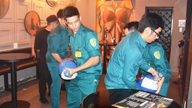 Đội tuần tra liên ngành quận 1, TPHCM và phường Phạm Ngũ Lão  lập biên bản tạm giữ các bình khí N2O tại một quán bar trên đường                Nguyễn Quang Đẩu vào khuya 29-9-2018.        Ảnh: QUANG HUY