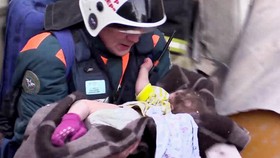 Các nhân viên cứu hộ đưa bé trai ra khỏi đống đổ nát. Nguồn: NBC NEWS 
