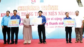Ông Ngô Thanh Trí - Phó Giám đốc Công ty XSKT Đồng Tháp  (bìa phải) nhận bảng tượng trưng trao nhà tình thương từ đơn vị tổ chức